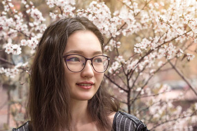 Portrait of beautiful young woman with cherry blossom