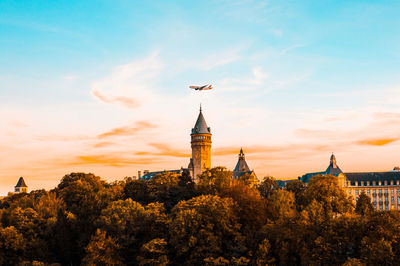 Tower in city against sky during sunset