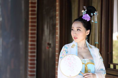 Beautiful young woman in traditional clothing looking away