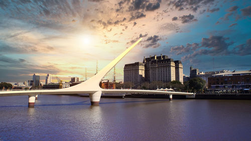 Bridge over river against buildings in city