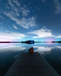 A couple sitting on a deck watching the stars of the night sky