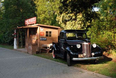 Vintage car on road against trees in city