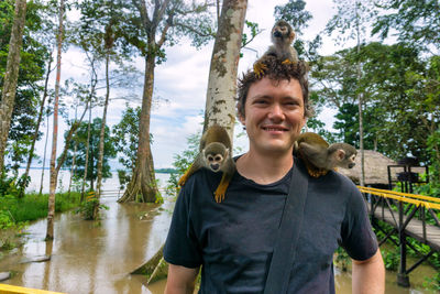 Portrait of smiling young man with monkeys