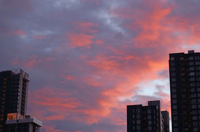 Amazing vibrant color sunset afterglow on the rain clouds over the city