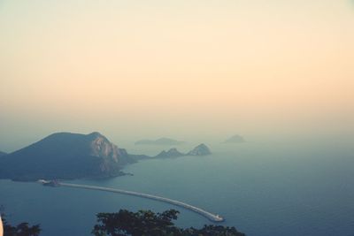 Scenic view of sea and mountains against clear sky