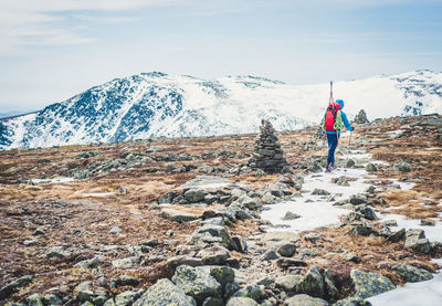 Man standing on snowcapped mountain against sky