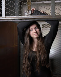 Portrait of young woman standing by window