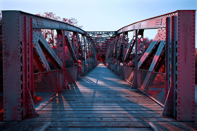 Footbridge over footpath against sky