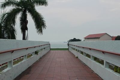 Footpath by swimming pool against sky