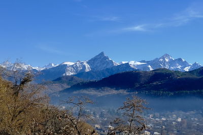 Scenic view of snowcapped mountains against blue sky