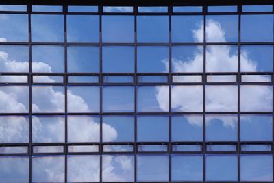 Reflection of summer blue sky and white clouds on the mirror of modern building. background concept.
