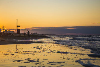 Scenic view of beach against clear sky during sunset