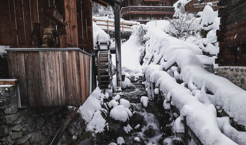 Snow covered field by building during winter