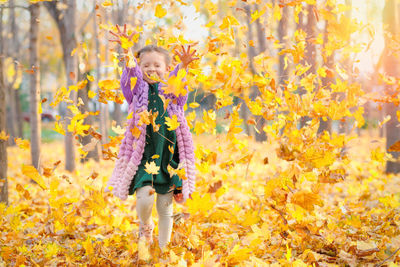 Full length of woman standing in forest during autumn