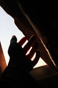 Close-up of hands against window