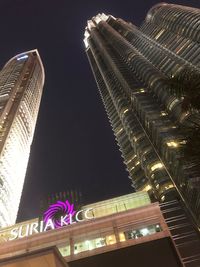 Low angle view of illuminated buildings against sky at night