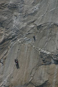 Low angle view of people climbing on rock