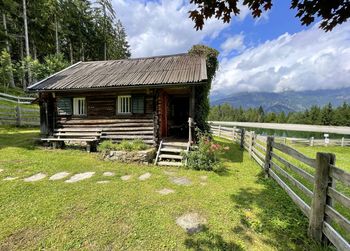 Wooden house on field against sky