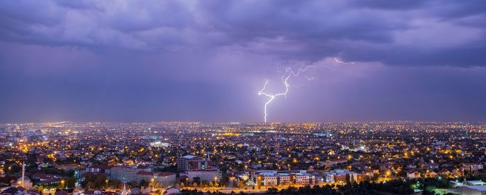 Aerial view of illuminated city against sky at night