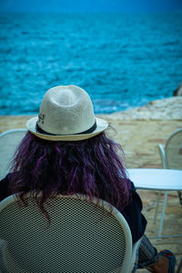 Rear view of woman wearing hat at beach