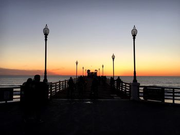 Silhouette of people at beach during sunset