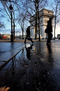 People on shore against sky in city