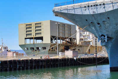 Ship moored at harbor against clear blue sky