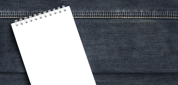 Directly above shot of empty spiral notebook on denim