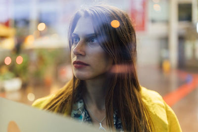 Portrait of young woman looking away outdoors