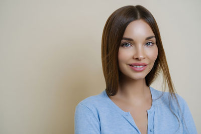 Portrait of young woman against white background
