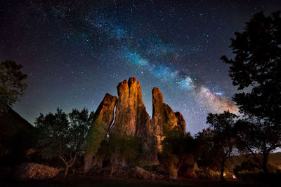 Low angle view of rock formation against sky at night