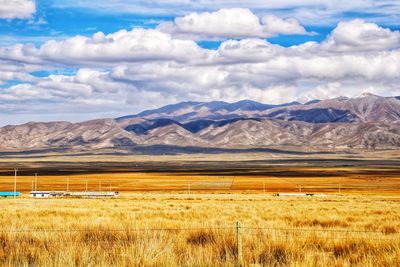 Scenic view of field and mountains against sky