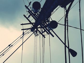 Low angle view of silhouette electricity pylon against sky