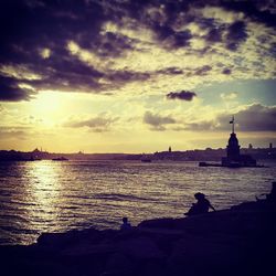 Scenic view of river against cloudy sky at sunset