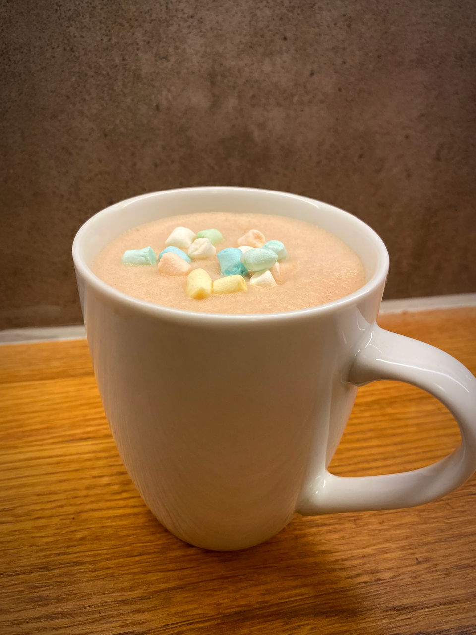 CLOSE-UP OF COFFEE CUP WITH SPOON AND TABLE