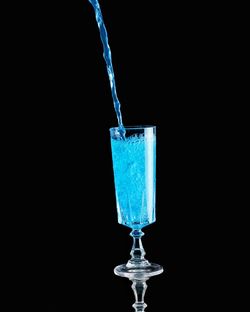 Close-up of drink in glass against black background