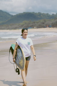 Portrait of young woman standing at beach