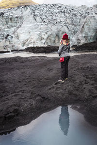 Rear view of woman standing on rock