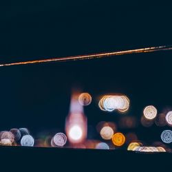Low angle view of illuminated lights against sky at night