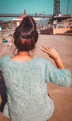 Rear view of woman standing by swimming pool