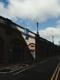 View of road sign against cloudy sky