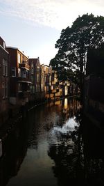 Canal amidst buildings against sky in city