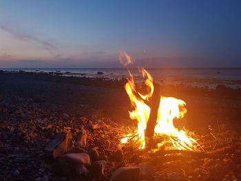 Bonfire on beach against sky during sunset