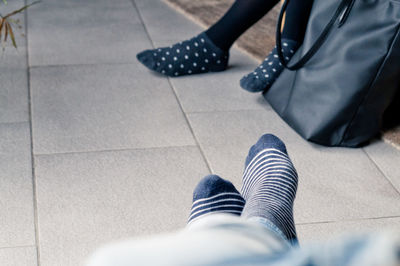 Low section of people wearing black socks at home