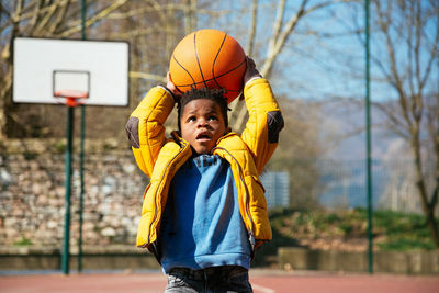 Boy playing with basketball at court