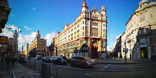 Panoramic view of city street and buildings against sky