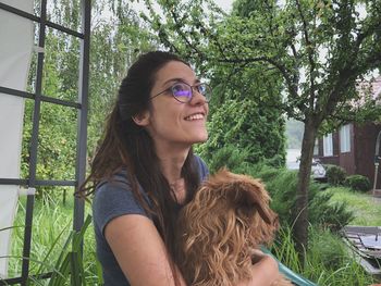 Portrait of smiling young woman against plants