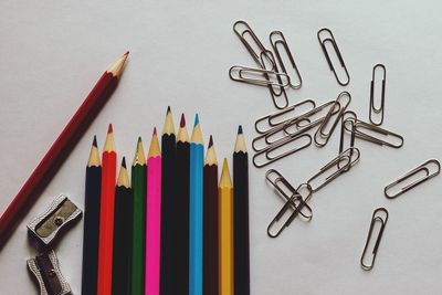 High angle view of colored pencils against white background