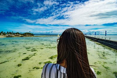 Rear view of woman looking at sea against sky