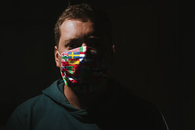 Close-up portrait of young man against black background